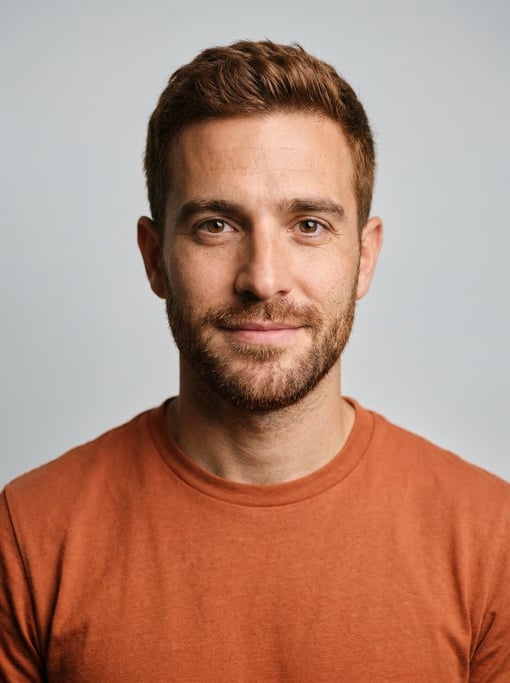 Professional studio headshot of a 30-year-old White Mediterranean man with short red-brown hair