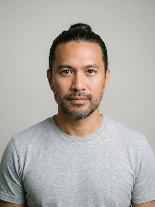 Professional studio headshot of a 40-year-old Filipino man with a man bun in dark brown