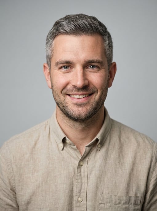 Professional studio headshot of a 29-year-old White British man with short salt-and-pepper hair neat