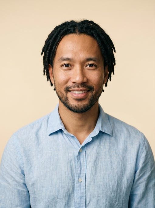 Professional studio headshot of a 36-year-old Vietnamese man with short locs in black