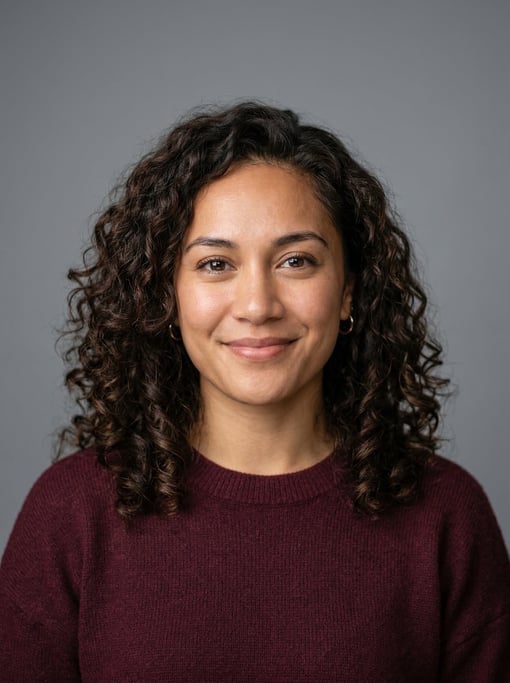 Professional studio headshot of a 25-year-old Pacific Islander woman with shoulder-length curly dark