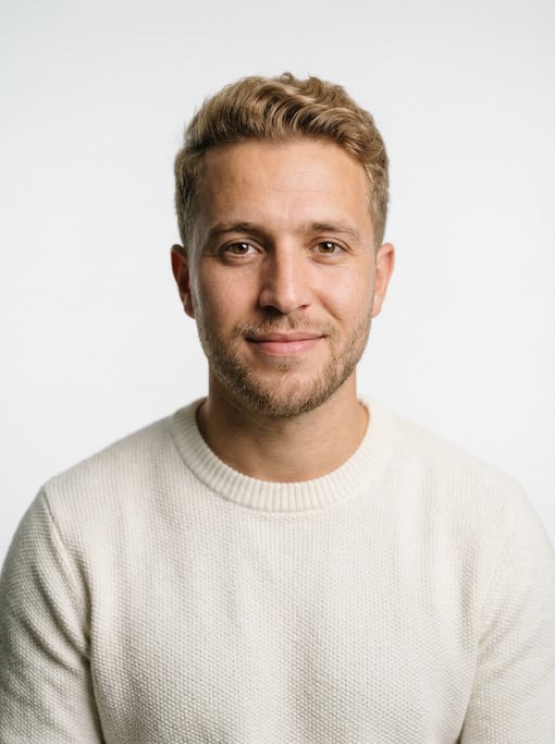 Professional studio headshot of a 26-year-old North African man with short dirty blonde hair
