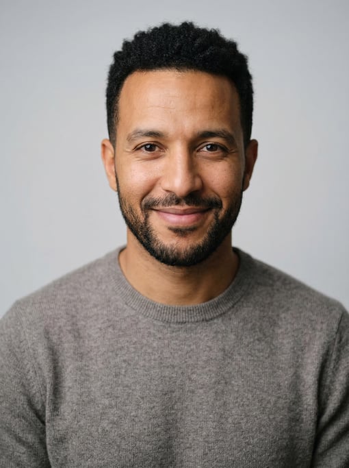 Professional studio headshot of a 35-year-old North African man with a black textured crop