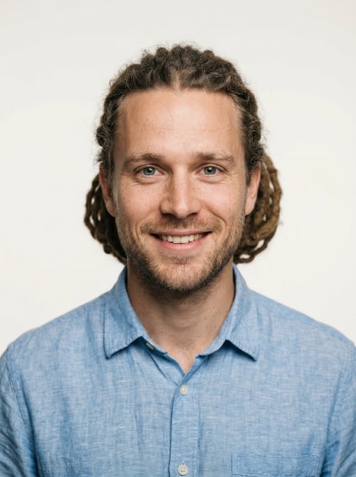 Professional studio headshot of a 28-year-old White Nordic man with medium dreadlocks pulled back