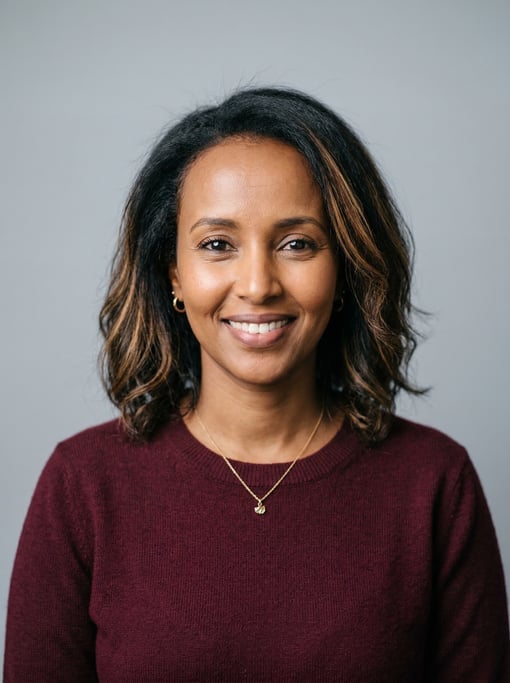 Professional studio headshot of a 37-year-old Somali woman with a textured lob with balayage highlig