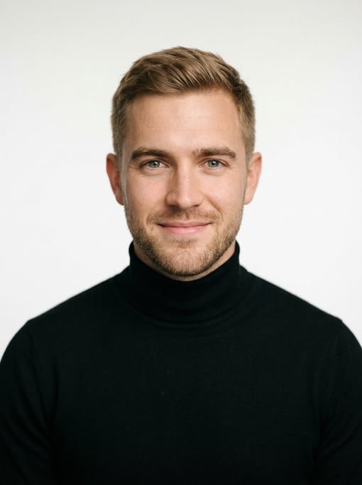 Professional studio headshot of a 27-year-old White European man with short cropped sandy brown hair