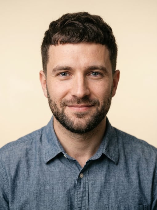 Professional studio headshot of a 31-year-old White Eastern European man with a French crop in dark