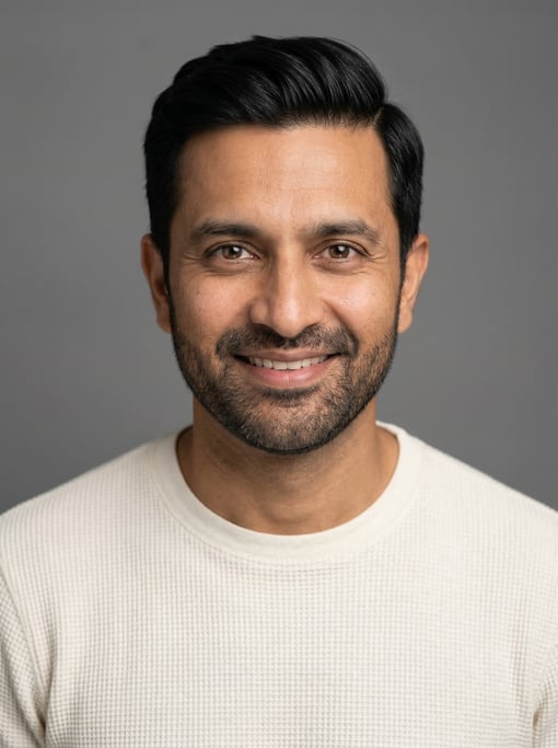 Professional studio headshot of a 40-year-old Indian man with neat black side-parted hair