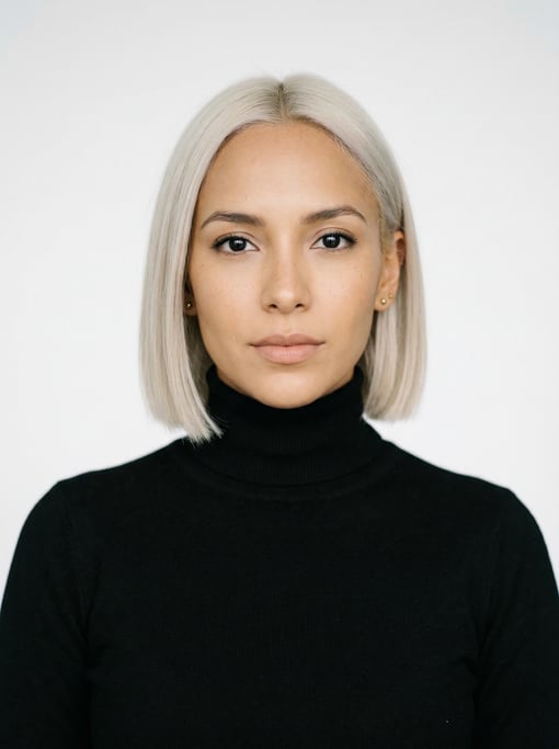 Professional studio headshot of a 28-year-old Colombian woman with a blunt bob in platinum blonde