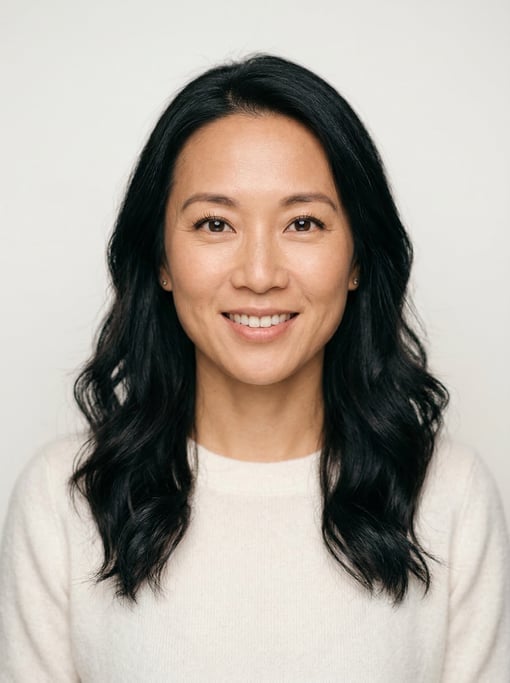 Professional studio headshot of a 37-year-old East Asian woman with long wavy black hair