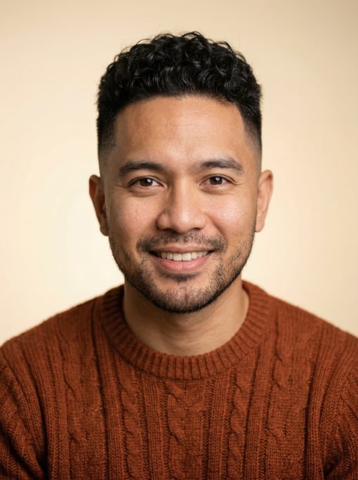 Professional studio headshot of a 29-year-old Filipino man with a skin fade with longer curly top