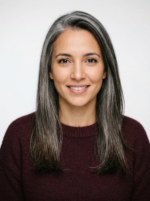 Professional studio headshot of a 30-year-old North African woman with long straight silver-streaked