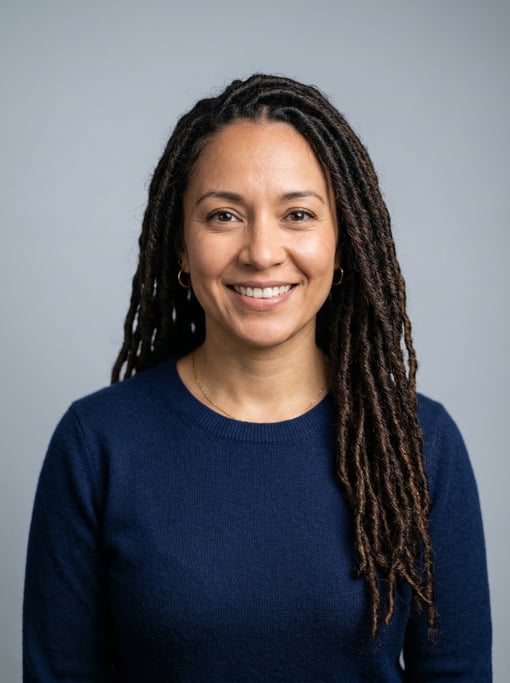 Professional studio headshot of a 36-year-old Latina woman with long goddess locs in dark brown