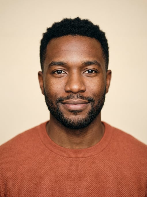 Professional studio headshot of a 29-year-old Black American man with short cropped black hair