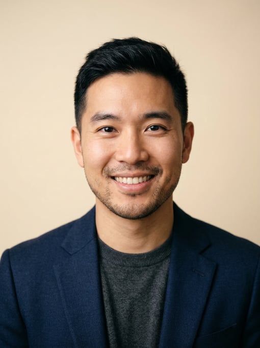 Professional studio headshot of a 32-year-old East Asian man with a Caesar cut in black