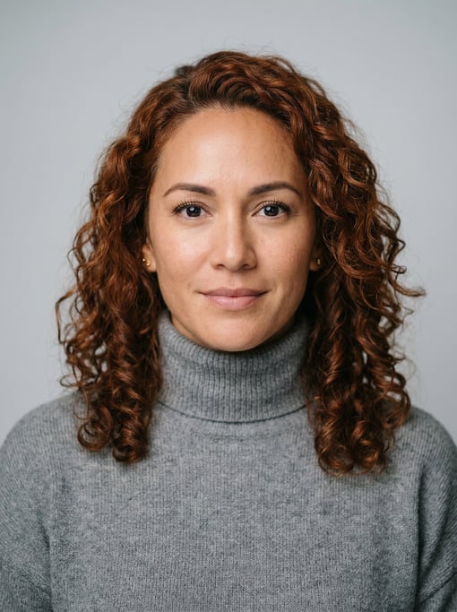 Professional studio headshot of a 38-year-old Hawaiian woman with shoulder-length curly auburn hair