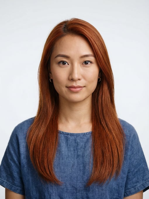 Professional studio headshot of a 25-year-old Chinese woman with long straight copper red hair
