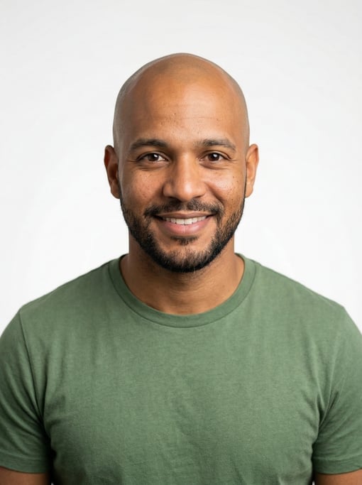 Professional studio headshot of a 29-year-old Dominican man with a completely bald head