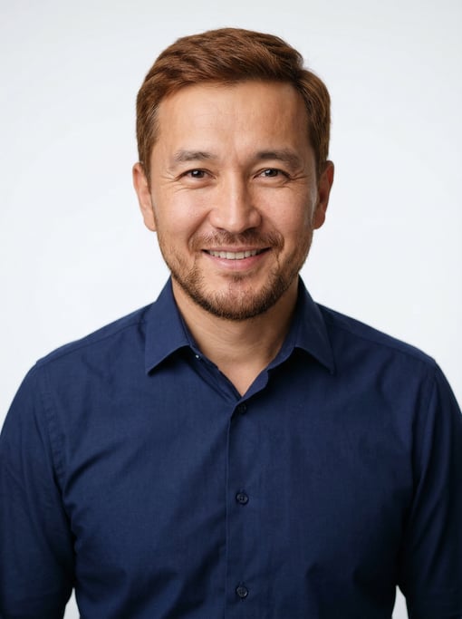 Professional studio headshot of a 38-year-old Central Asian man with short auburn hair