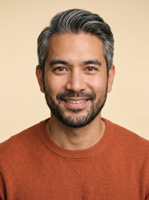 Professional studio headshot of a 36-year-old Thai man with silver-streaked dark hair combed back
