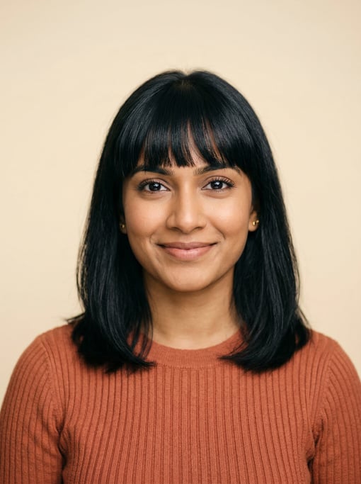 Professional studio headshot of a 28-year-old Sri Lankan woman with blunt bangs with shoulder-length