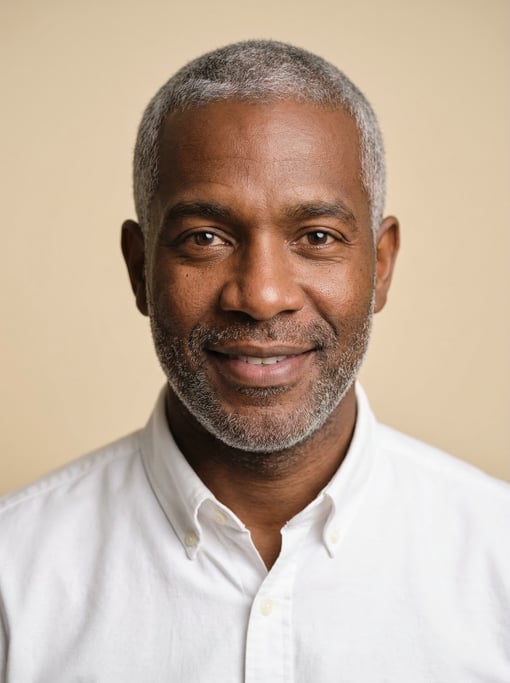 Professional studio headshot of a 38-year-old Jamaican man with fully grey short cropped hair