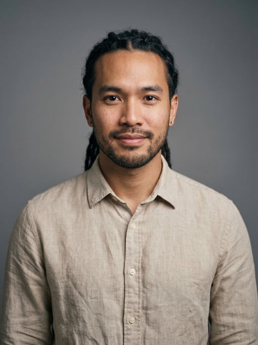 Professional studio headshot of a 28-year-old Thai man with medium dreadlocks pulled back