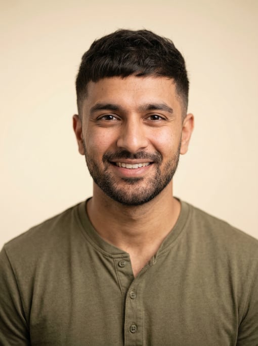 Professional studio headshot of a 27-year-old South Asian man with a French crop in dark brown