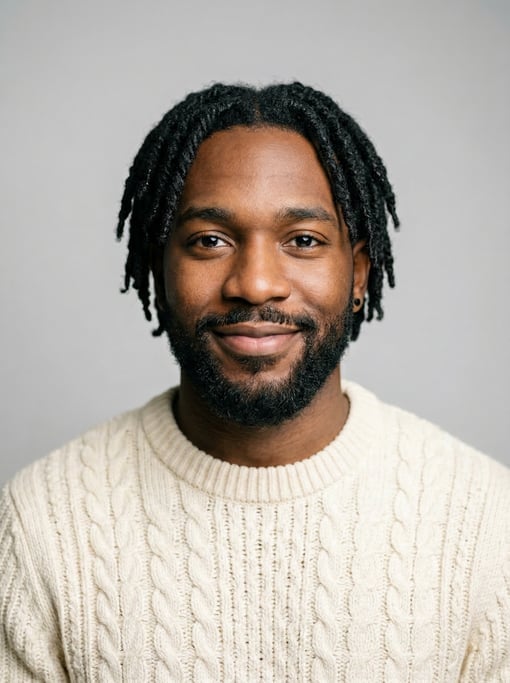 Professional studio headshot of a 27-year-old Black American man with short locs in black