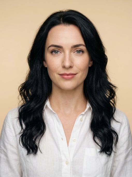 Professional studio headshot of a 26-year-old White British woman with long wavy black hair