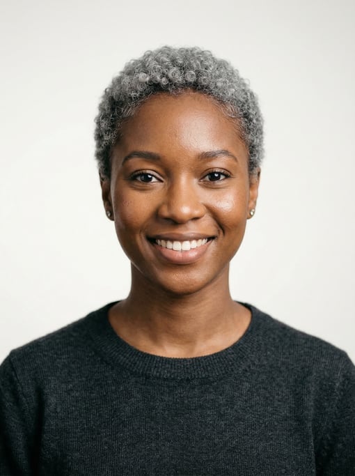 Professional studio headshot of a 25-year-old West African woman with a short curly silver-grey crop