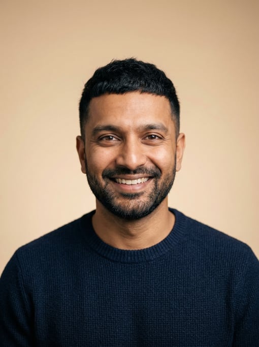 Professional studio headshot of a 35-year-old Indian man with a black textured crop
