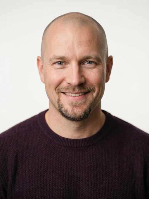 Professional studio headshot of a 39-year-old White Nordic man with a shaved head, a goatee