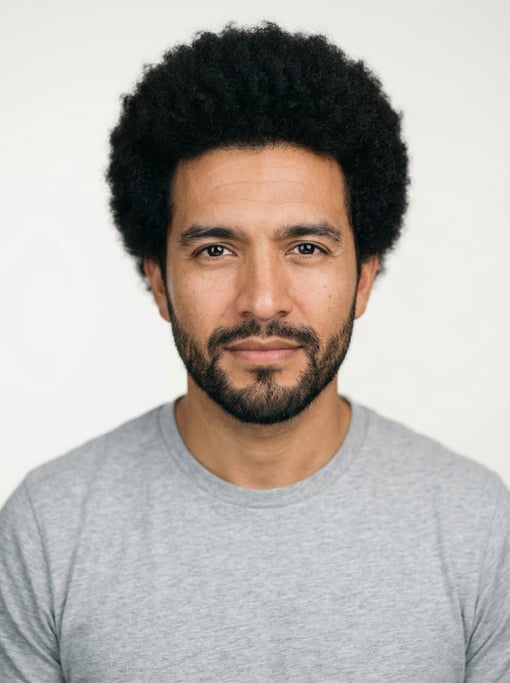 Professional studio headshot of a 32-year-old Mexican man with a medium natural afro in black