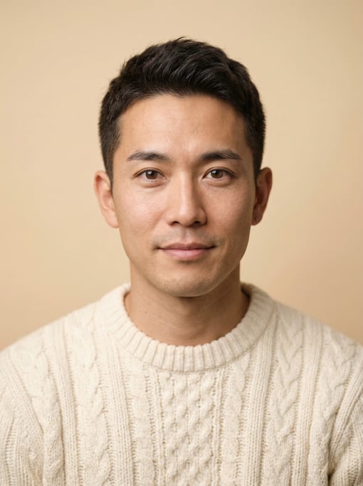 Professional studio headshot of a 32-year-old Japanese man with a dark brown textured crop