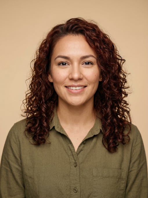 Professional studio headshot of a 26-year-old Native American woman with shoulder-length curly aubur