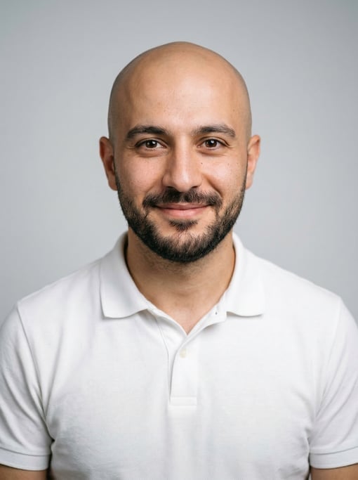 Professional studio headshot of a 27-year-old Turkish man with a shaved head