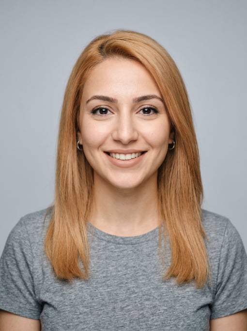 Professional studio headshot of a 25-year-old Middle Eastern woman with fine straight strawberry blo