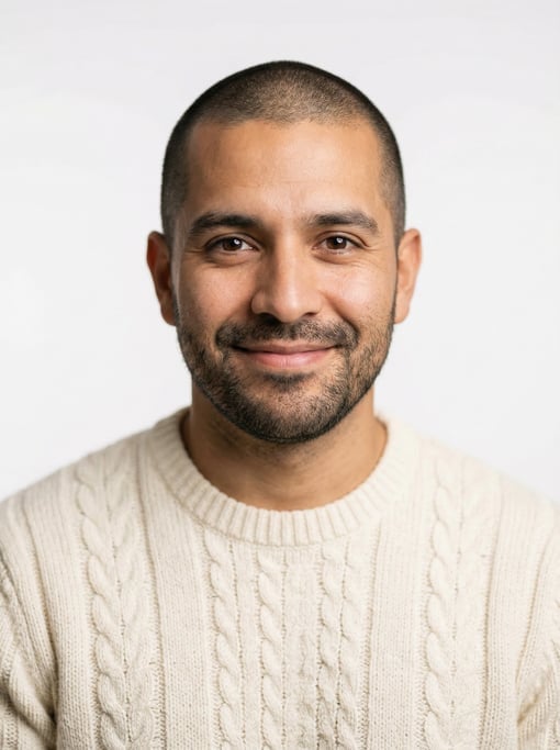 Professional studio headshot of a 32-year-old Latino man with a buzz cut in brown