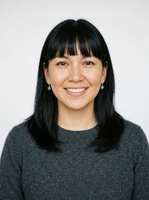 Professional studio headshot of a 28-year-old Native American woman with blunt bangs with shoulder-l