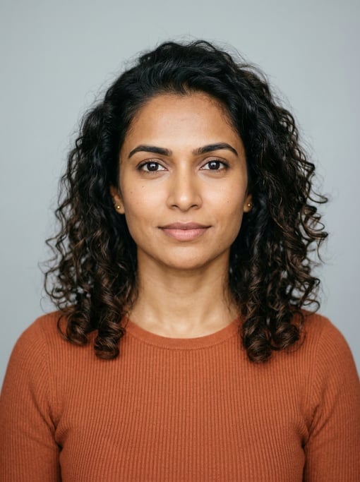 Professional studio headshot of a 31-year-old Sri Lankan woman with shoulder-length curly dark brown