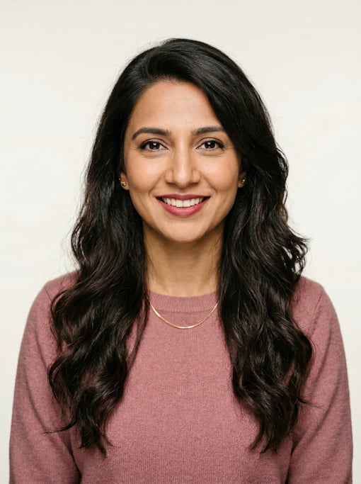 Professional studio headshot of a 34-year-old Pakistani woman with a deep side part with long brown