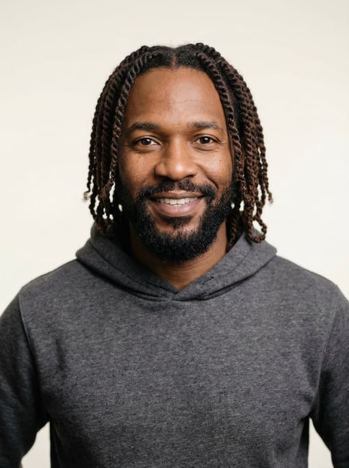 Professional studio headshot of a 39-year-old Black African man with twists in dark brown