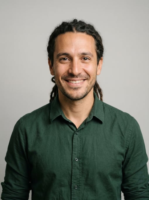 Professional studio headshot of a 35-year-old Argentinian man with medium dreadlocks pulled back