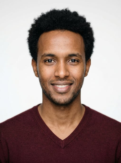 Professional studio headshot of a 27-year-old Somali man with a short natural afro in black