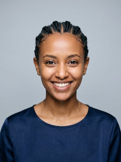 Professional studio headshot of a 25-year-old Ethiopian woman with cornrows pulled back neatly