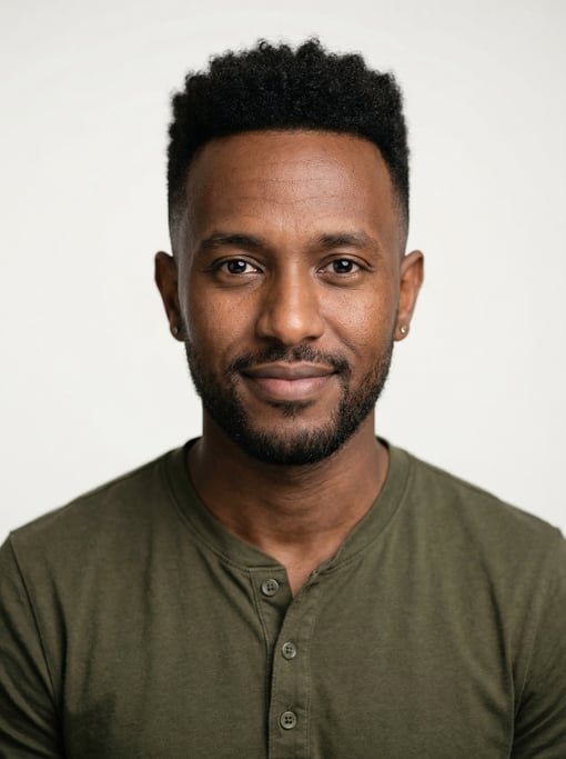 Professional studio headshot of a 32-year-old East African man with a high fade with short curly top