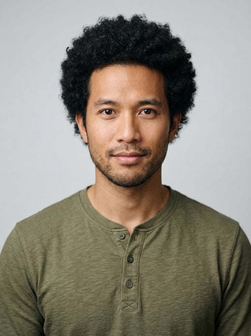 Professional studio headshot of a 30-year-old Vietnamese man with a medium natural afro in black