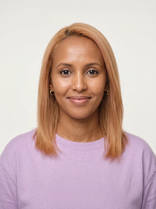 Professional studio headshot of a 35-year-old Somali woman with fine straight strawberry blonde hair