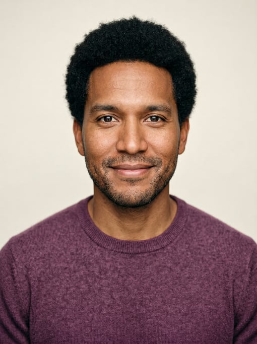 Professional studio headshot of a 36-year-old Native American man with a short natural afro in black